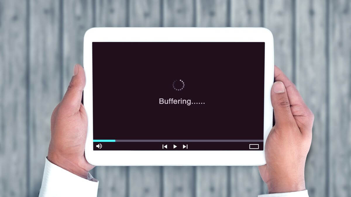 Hands holding a white tablet displaying a loading screen, representing image.
