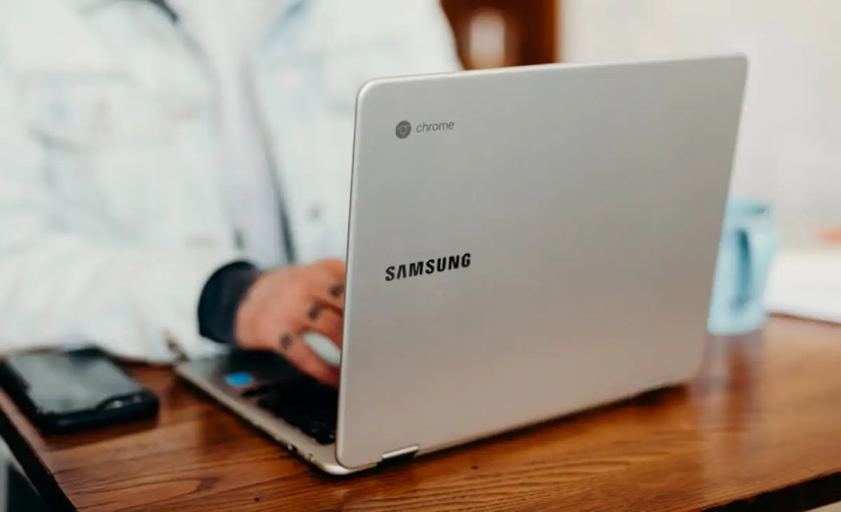 A blue Chromebook laptop resting on a wooden table, showcasing image.